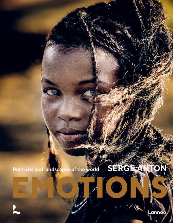 Book cover of Emotions: Portraits and Landscapes of the World; featuring a portrait of African girl smiling at camera. Published by Lannoo Publishers.