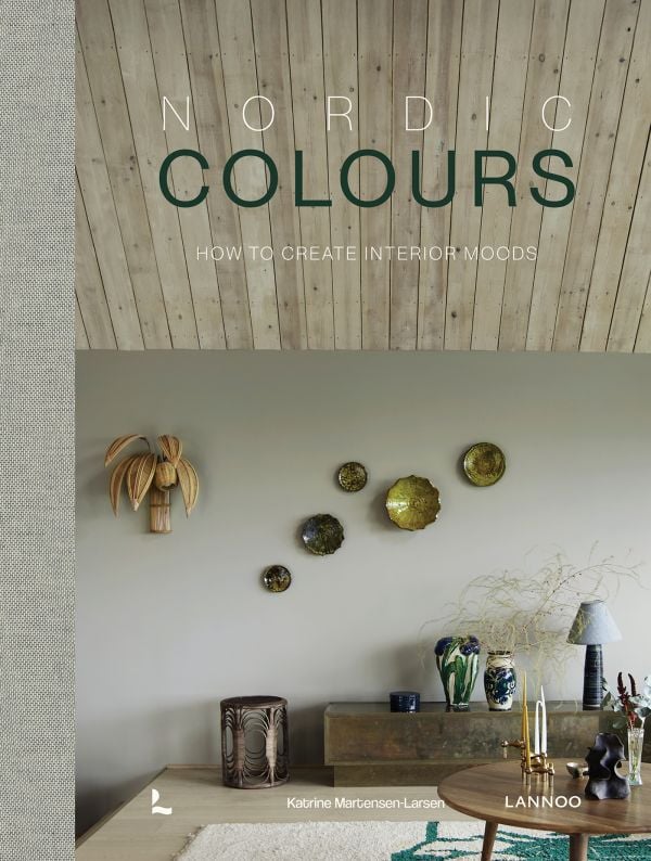 Book cover of Nordic Colours: How to create interior moods; featuring an interior living room with wood panelled celling and wood furniture. Published by Lannoo Publishers.