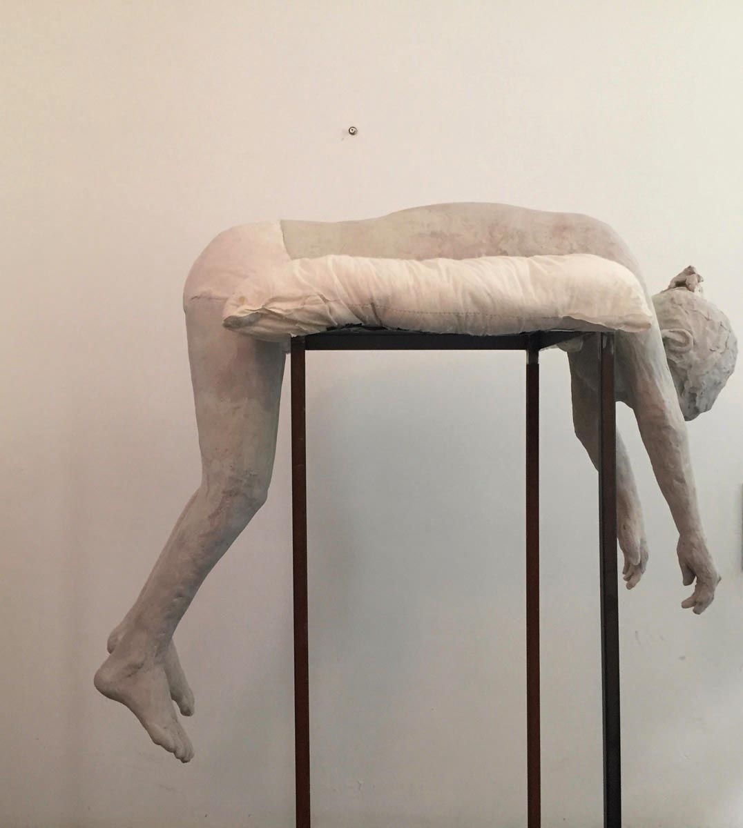 Life sized clay sculpture of girl sitting on bed, Breath in pale grey font above