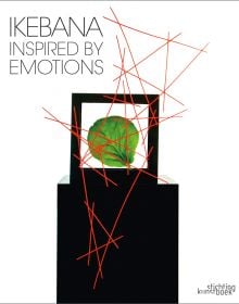 Book cover of Ikebana Inspired by Emotions, featuring a box with a green leaf inside, with an abstract sculpture of red sticks. Published by Stichting.