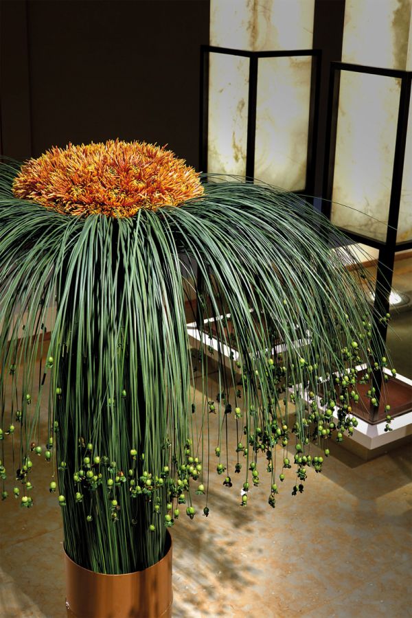 Book cover of Gary Kwok's Flowers and Design, with two glass holders filled with thin green stems topped with tiny bright blue flowers. Published by Stichting.