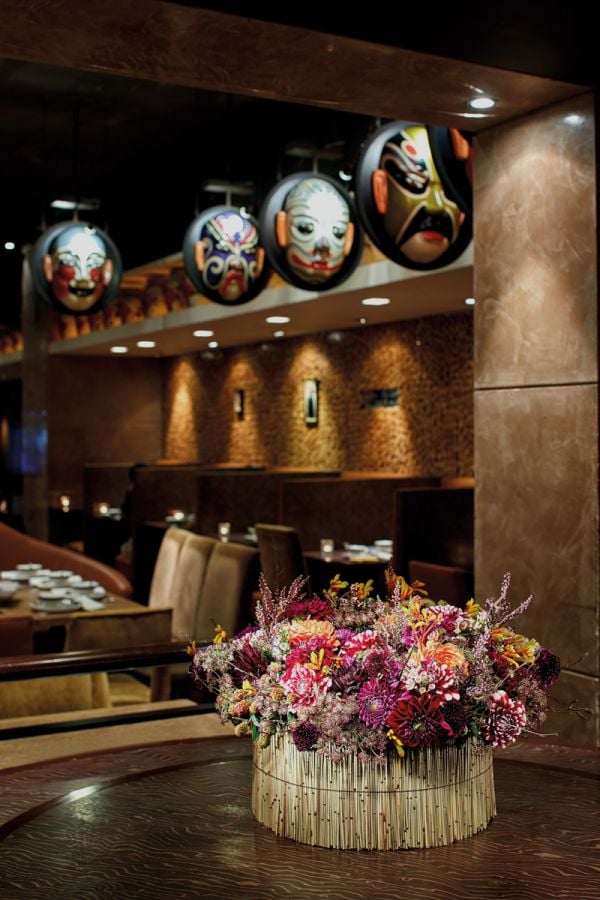 Book cover of Gary Kwok's Flowers and Design, with two glass holders filled with thin green stems topped with tiny bright blue flowers. Published by Stichting.