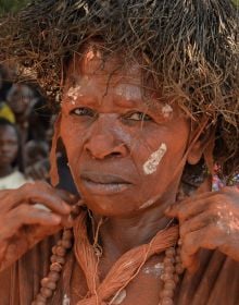 Book cover of Congo Revisited, featuring an African girl holding red onion to lips, bunch of onions resting on head. Published by Stichting.