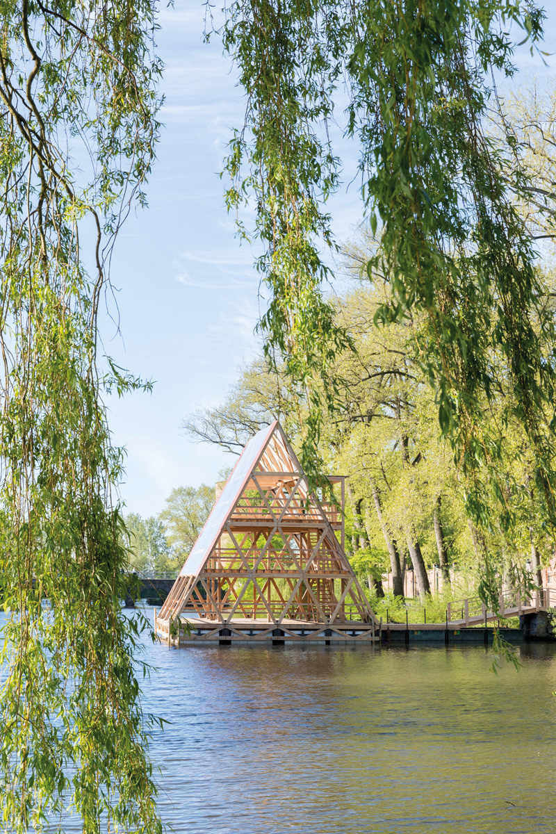 Large red and yellow cocoon installation, floating on water with locks, VLOEIBARE STAD LIQUID CITY, in red font, TRIENNALE BRUGGES 2018 on white border