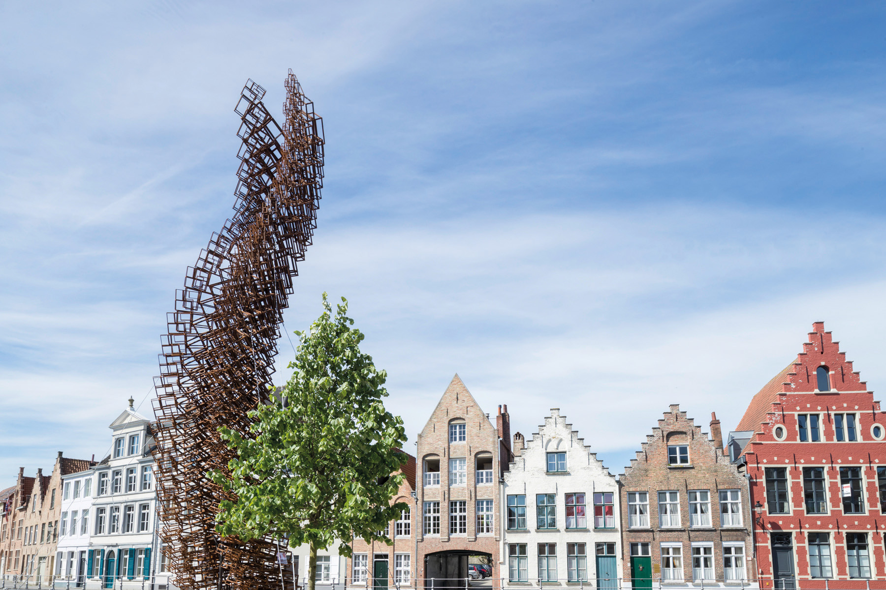 Large red and yellow cocoon installation, floating on water with locks, VLOEIBARE STAD LIQUID CITY, in red font, TRIENNALE BRUGGES 2018 on white border