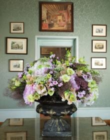 Book cover of The Bouquets of Chenonceau, featuring a bouquet of flowers in a large urn with base, in front of decorative fireplace. Published by Stichting.