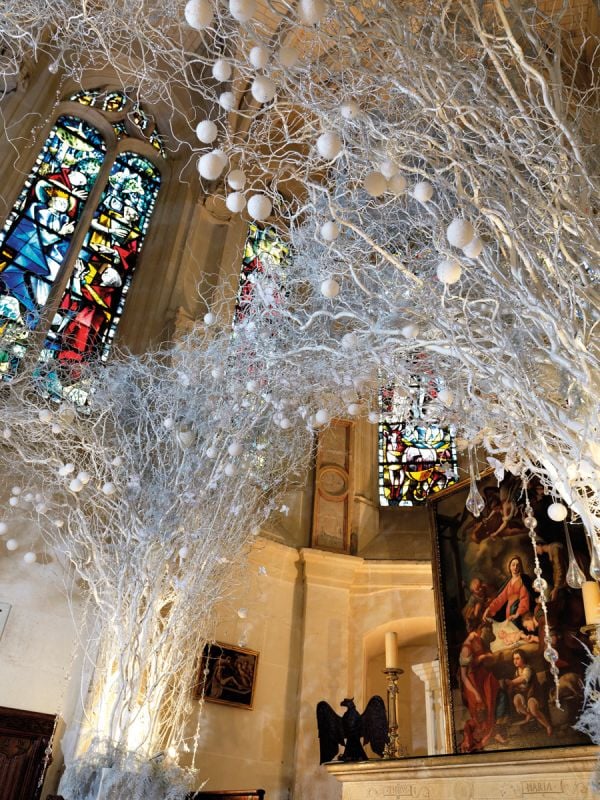 Book cover of The Bouquets of Chenonceau, featuring a bouquet of flowers in a large urn with base, in front of decorative fireplace. Published by Stichting.