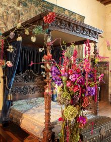 Book cover of The Art of Flower Arranging, Château de Chaumont-sur-Loire featuring a large ornate fireplace with pink, green and white floral arrangement on small dark wood table below. Published by Stichting.