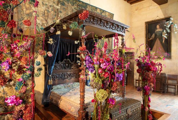 Book cover of The Art of Flower Arranging, Château de Chaumont-sur-Loire featuring a large ornate fireplace with pink, green and white floral arrangement on small dark wood table below. Published by Stichting.