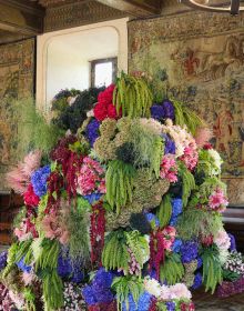 Book cover of The Art of Flower Arranging, Château de Chaumont-sur-Loire featuring a large ornate fireplace with pink, green and white floral arrangement on small dark wood table below. Published by Stichting.