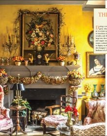 Book cover of Laura Dowling Designing Christmas: Practical Tips for Festive Decor, with an interior hallway with a large floral wreath on the door, Published by Stichting Kunstboek.