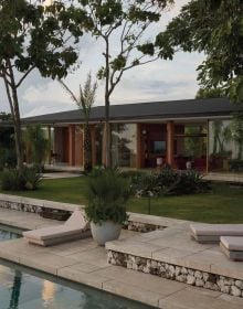 Book cover of Tropical Retreats; featuring an interior living space with wood furniture and bamboo beams. Published by Lannoo Publishers.
