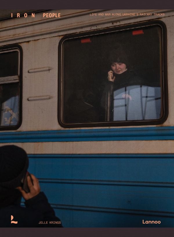 Book cover of Iron People: Life and War Along Ukraine’s Railway Tracks; with person on a mobile phone, looking out of a train window. Published by Lannoo Publishers.