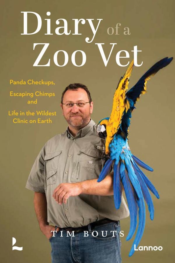 Book cover of Diary of a Zoo Vet: Panda Checkups, Escaping Chimps and Life in the Wildest Clinic on Earth; featuring a vet holding a blue-and-yellow macaw on his left arm. Published by Lannoo Publishers.