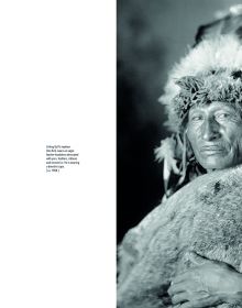 Black and white portrait of Fort Yate Native American tribesman, feather in hair, beads around neck, on cover of 'The Standing Rock Portraits, Sioux Photographed by Frank Bennett Fiske 1900-1915', by Lannoo Publishers.