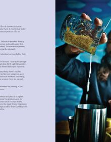 Stemmed cocktail glass containing red liquid, bright blue smoky background, on cover of 'High Cocktails, Psychoactive Non-Alcoholic Cocktails', by Lannoo Publishers.