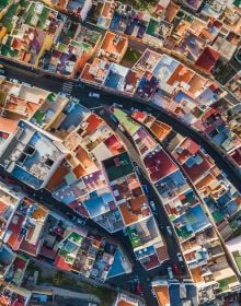 Book cover of Man Made, Aerial Views of Human Landscapes, with an aerial shot of house surrounded by boats on water. Published by Lannoo Publishers.