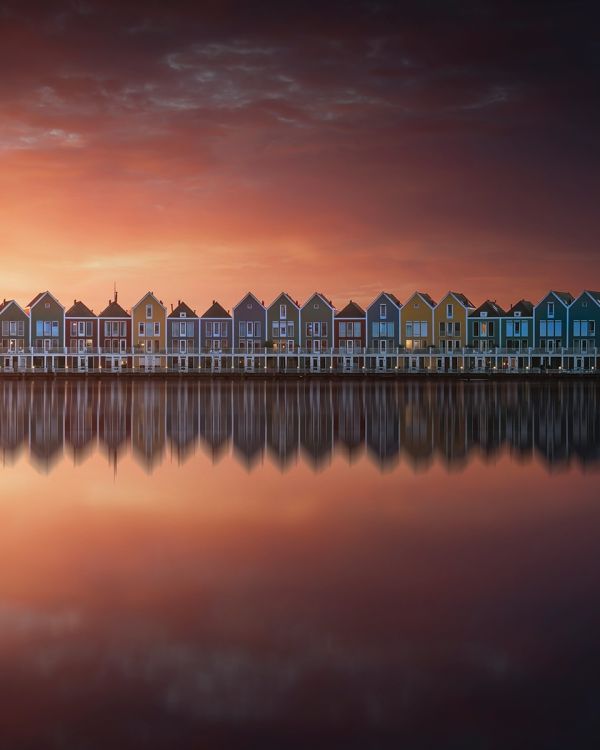 Book cover of Man Made, Aerial Views of Human Landscapes, with an aerial shot of house surrounded by boats on water. Published by Lannoo Publishers.