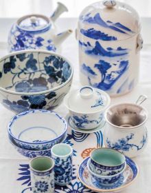 Book cover of Tea', Wine's Sober Sibling, with green tea leaves on blue plate. Published by Lannoo Publishers.