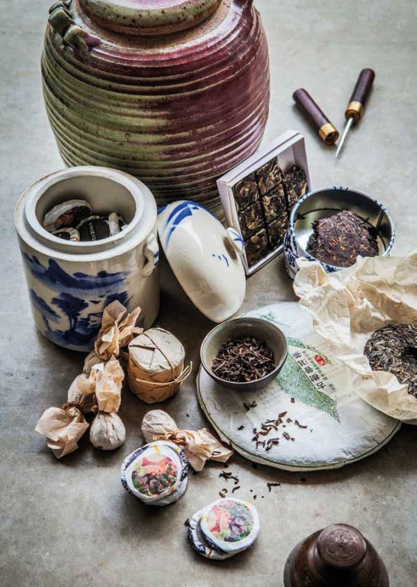 Book cover of Tea', Wine's Sober Sibling, with green tea leaves on blue plate. Published by Lannoo Publishers.