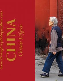 An older Chinese man in navy slacks walking through street, on landscape cover of 'China, Seen Through a Photographers Eyes', by Booxencounters.