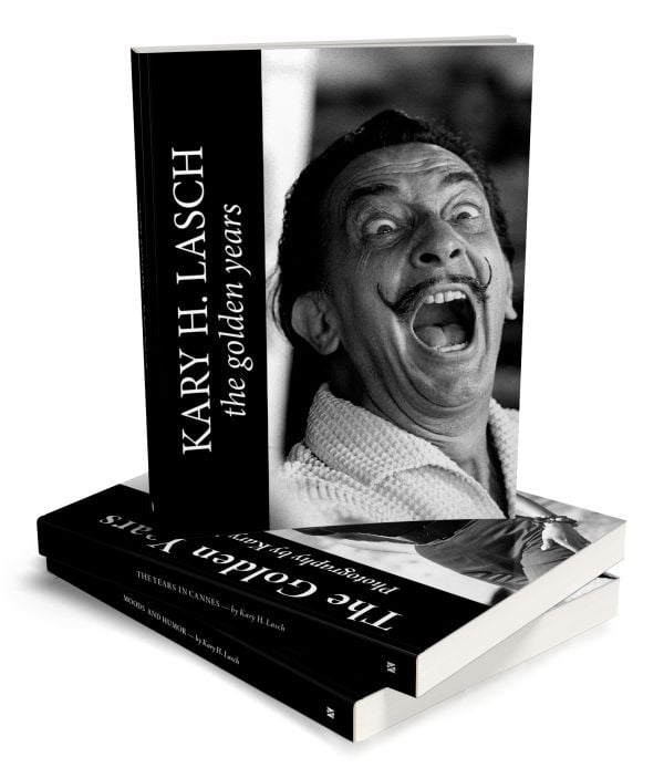 Surrealist painter Salvador Dali mid shout or laugh with mouth and eyes wide open, on cover of 'Kary H. Lasch The Golden Years', by Booxencounters.
