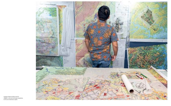 Book cover of New Capital: Building Cities From Scratch, with a construction worker mixing cement, with stone columns behind. Published by Lannoo Publishers.