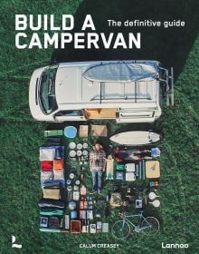 Book cover of Build a Campervan: The Definitive Guide, featuring an aerial view of a campervan with its contents laid out on the grass. Published by Lannoo Publishers.