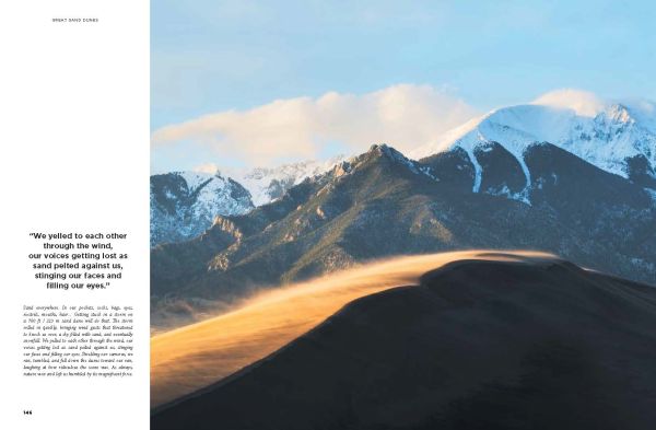 Campervan on straight road with mountainous landscape behind and orange sky, on cover of 'Roaming America, Exploring All the National Parks', by Lannoo Publishers.