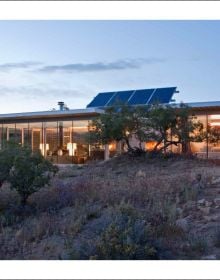 Modern, luxury cabin on remote Norwegian island, covered in snow, on cover of 'Nature View, The Perfect Holiday Homes', by Lannoo Publishers.