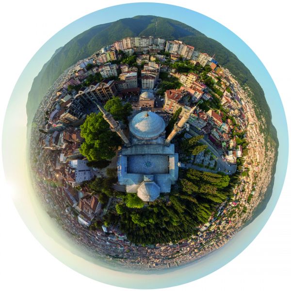 Aerial view of car on road driving through desert, on cover of 'Flatland', by Lannoo Publishers.
