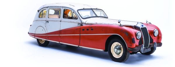 Old unrestored classic car with light blue panels on white cover of 'Mahy. A Family of Cars, The Tranquil Beauty of Unique Classic Cars', by Lannoo Publishers.