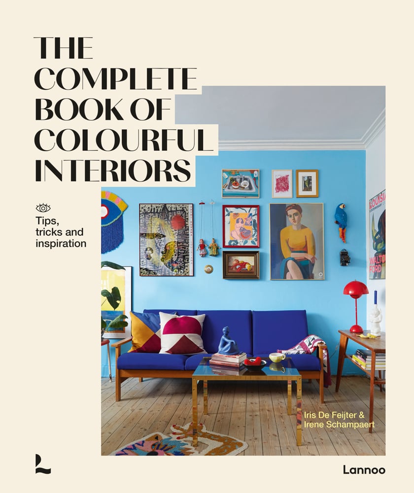 Photo of interior space wooden floor, blue wall with framed paintings on off white cover and The Complete Book of Colourful Interiors in black font