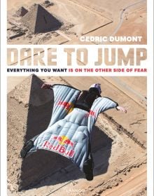Skydiver in Red Bull wingsuit, gliding high up over Pyramids, on cover of 'Dare to Jump, Everything You Want is on the other Side of Fear', by Lannoo Publishers.