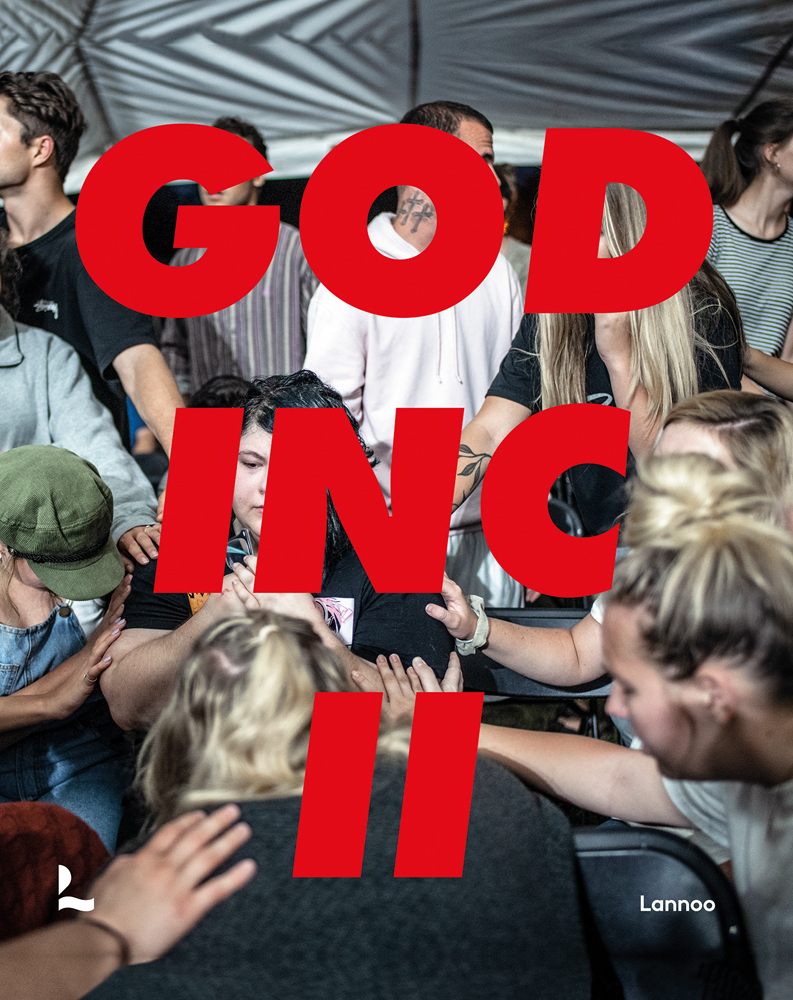 Group of people at religious convention, placing hands on each others backs, GOD INC II in large red font across cover.