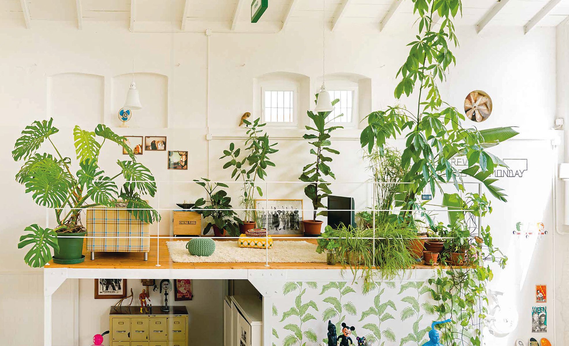 Aerial view of living space with tropical green foliage, palm leaves, 2 deckchairs, on pale pink cover of 'Ultimate Wonder Plants, Your Urban Jungle Interior', by Lannoo Publishers.