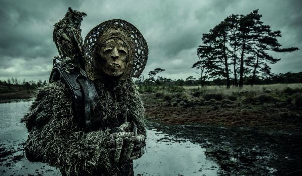 Skull masked figure in gold and white ruffled clothing, cradling white dove, on cover of 'Mothmeister: Dark and Dystopian Post-Mortem Fairy Tales', by Lannoo Publishers.