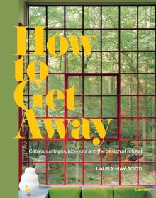Green forest through large red paned window, on cover of 'How To Get Away, Cabins, cottages, hideouts and the design of retreat', by Lannoo Publishers.