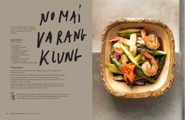 Book cover of The Thai Kitchen of Boo Raan, Sharing Recipes From Dokkoon Kapueak, with an Asian style chicken dish in restaurant kitchen, with chef topping with herbs. Published by Lannoo Publishers.