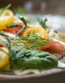 Plate of small green and yellow stacked canapes, on cover of 'Wild Cooking, Surprising Seasonal Dishes With Fresh Vegetables and Fruits', by Lannoo Publishers.