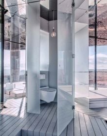 Illuminated interior living space, surrounded by carved rock, on cover of 'Hidden Architecture, Buildings that Blend In', by Lannoo Publishers