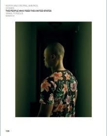 Book cover of World Press Photo 2022, with orange and cream summer dresses hanging from three wooden crosses in ground. Published by Lannoo Publishers.