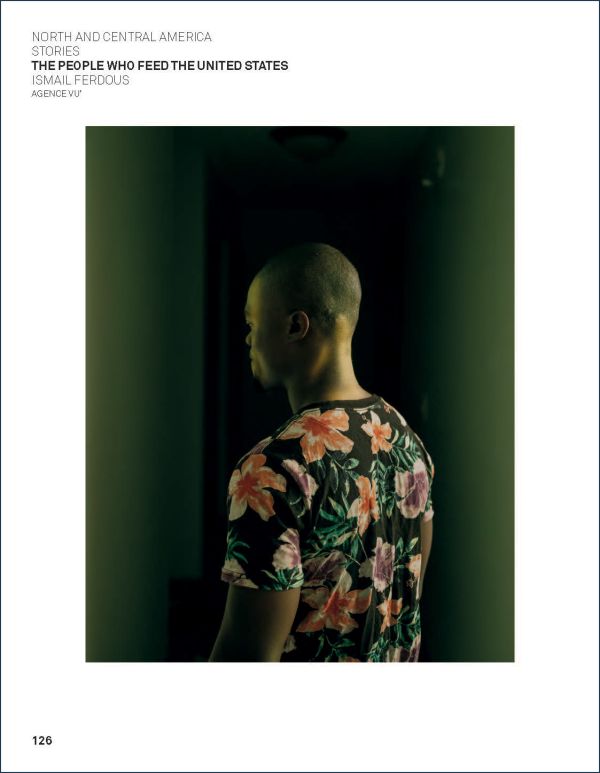 Book cover of World Press Photo 2022, with orange and cream summer dresses hanging from three wooden crosses in ground. Published by Lannoo Publishers.