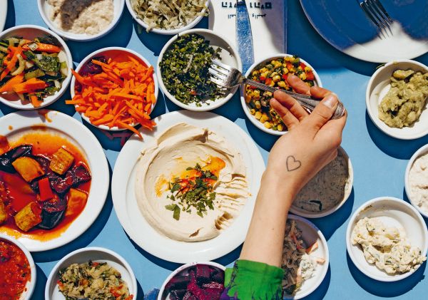 Large capitalised black font on custard yellow cover of 'Boker Tov, A culinary love story from Tel Aviv', by Lannoo Publishers.