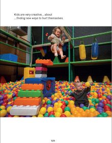 Book cover of Adventures With Dad Being a Father is Child's Play, with a father sitting next to playing field with two small children, one flying off ramp in plastic car. Published by Lannoo Publishers.