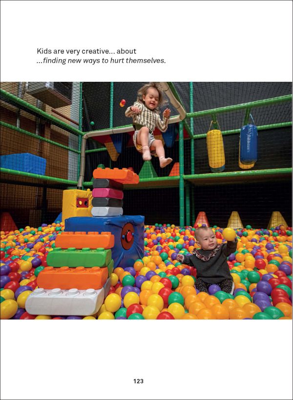 Book cover of Adventures With Dad Being a Father is Child's Play, with a father sitting next to playing field with two small children, one flying off ramp in plastic car. Published by Lannoo Publishers.