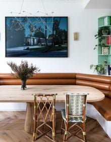 Interior living room with high ceiling, green walls, blue velvet chair, fireplace, on cover of 'London Interiors', by Lannoo Publishers.