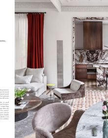 White Mediterranean interior space with white sofa, low hanging light, family portrait painting on wall, on cover of 'Barcelona Interiors', by Lannoo Publishers.
