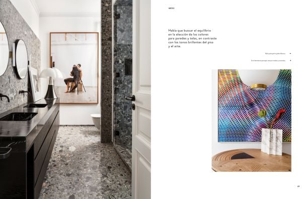 Book cover of Barcelona Interiors, with a white Mediterranean interior space with white sofa, low hanging light, and family portrait painting on wall. Published by Lannoo Publishers.