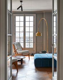 Interior living space with bronze figure on coffee table, framed portrait sketch on wall, on cover of 'Homes for Collectors', by Lannoo Publishers.